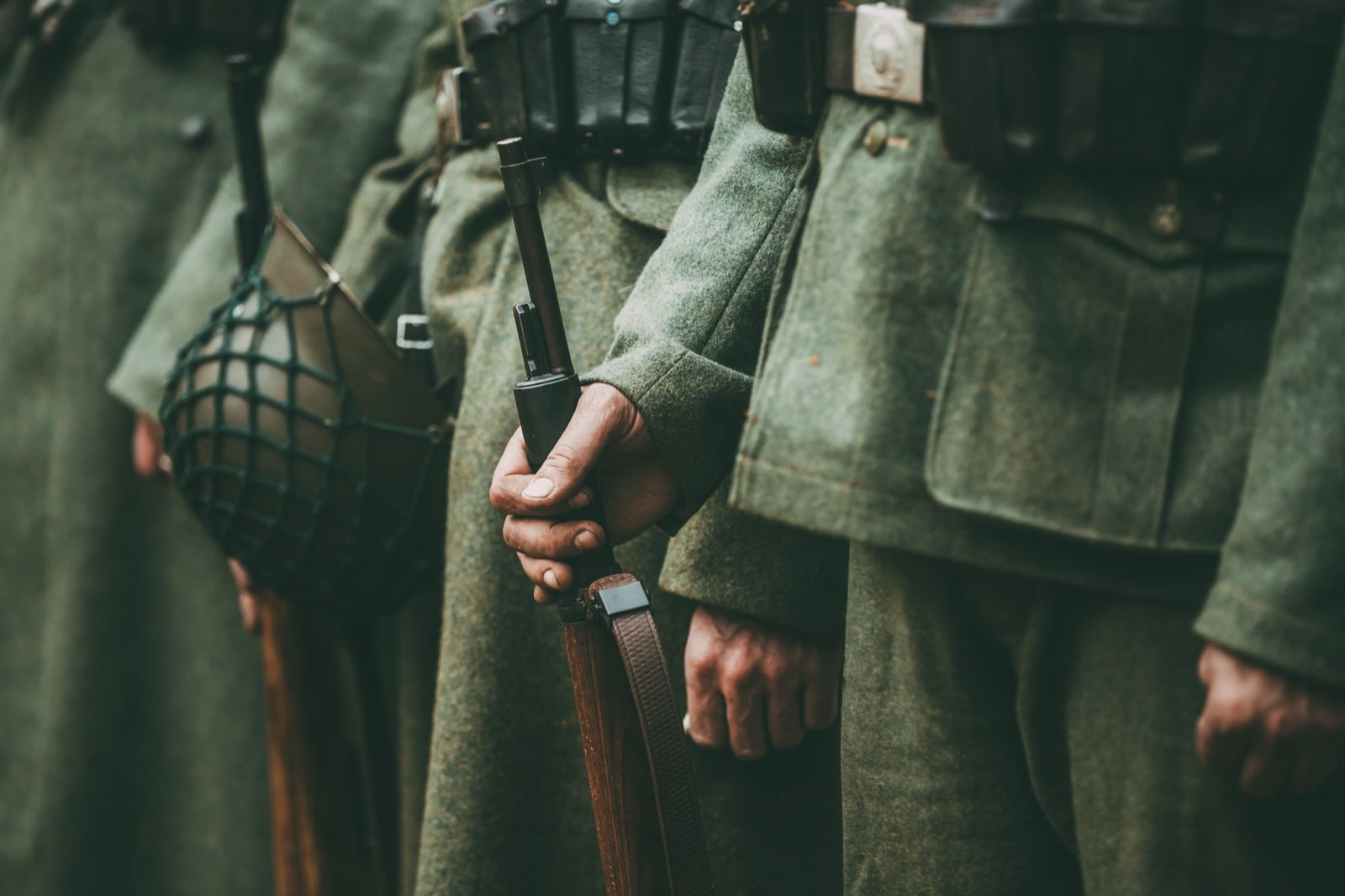 Soldiers standing in uniform holding rifles and wearing helmets