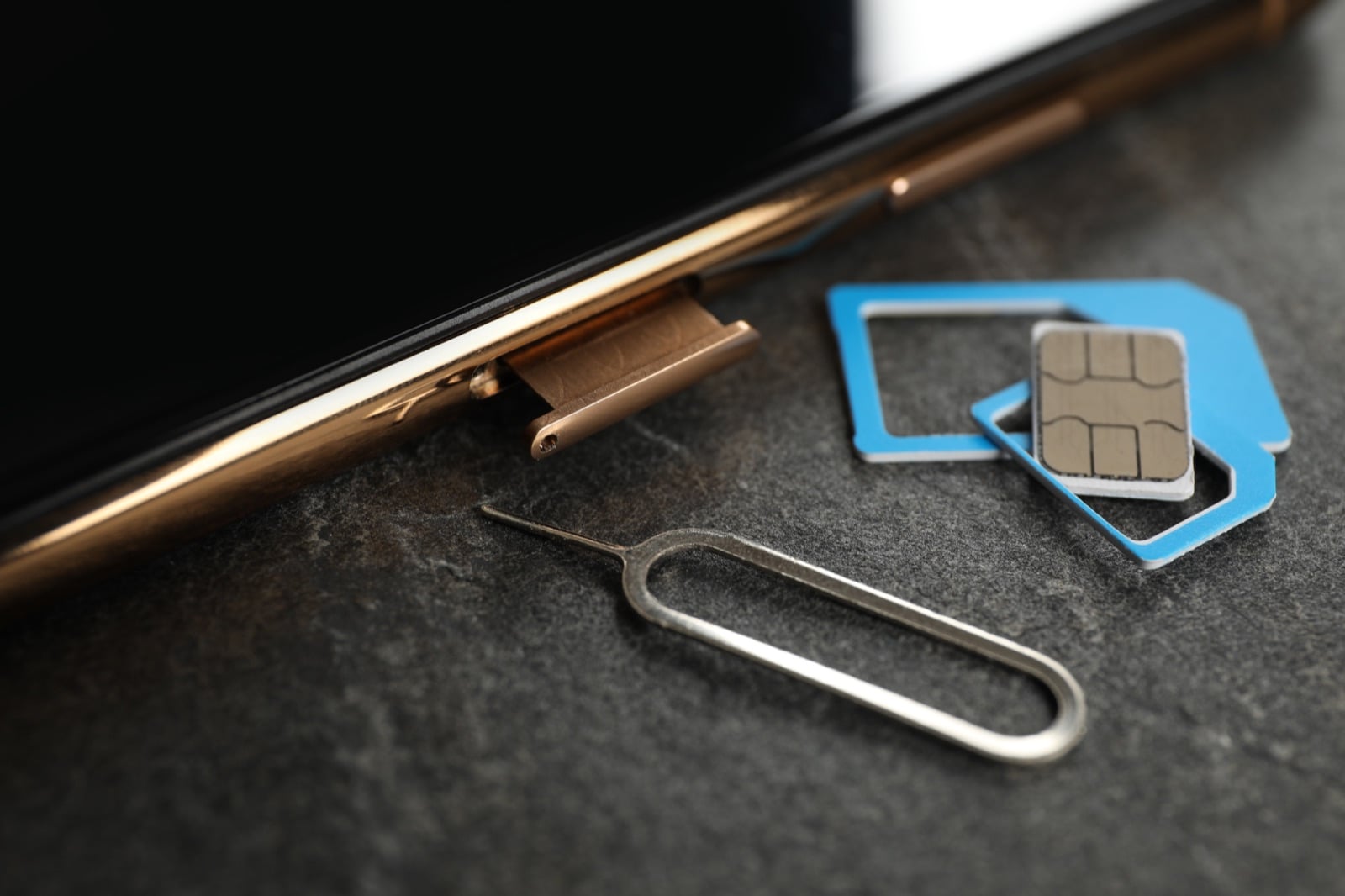 Close-up of a phone with a SIM card and ejector tool