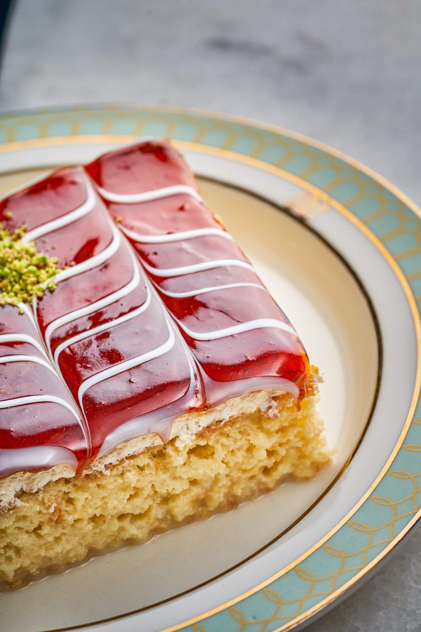 Slice of layered dessert with a red glaze topping