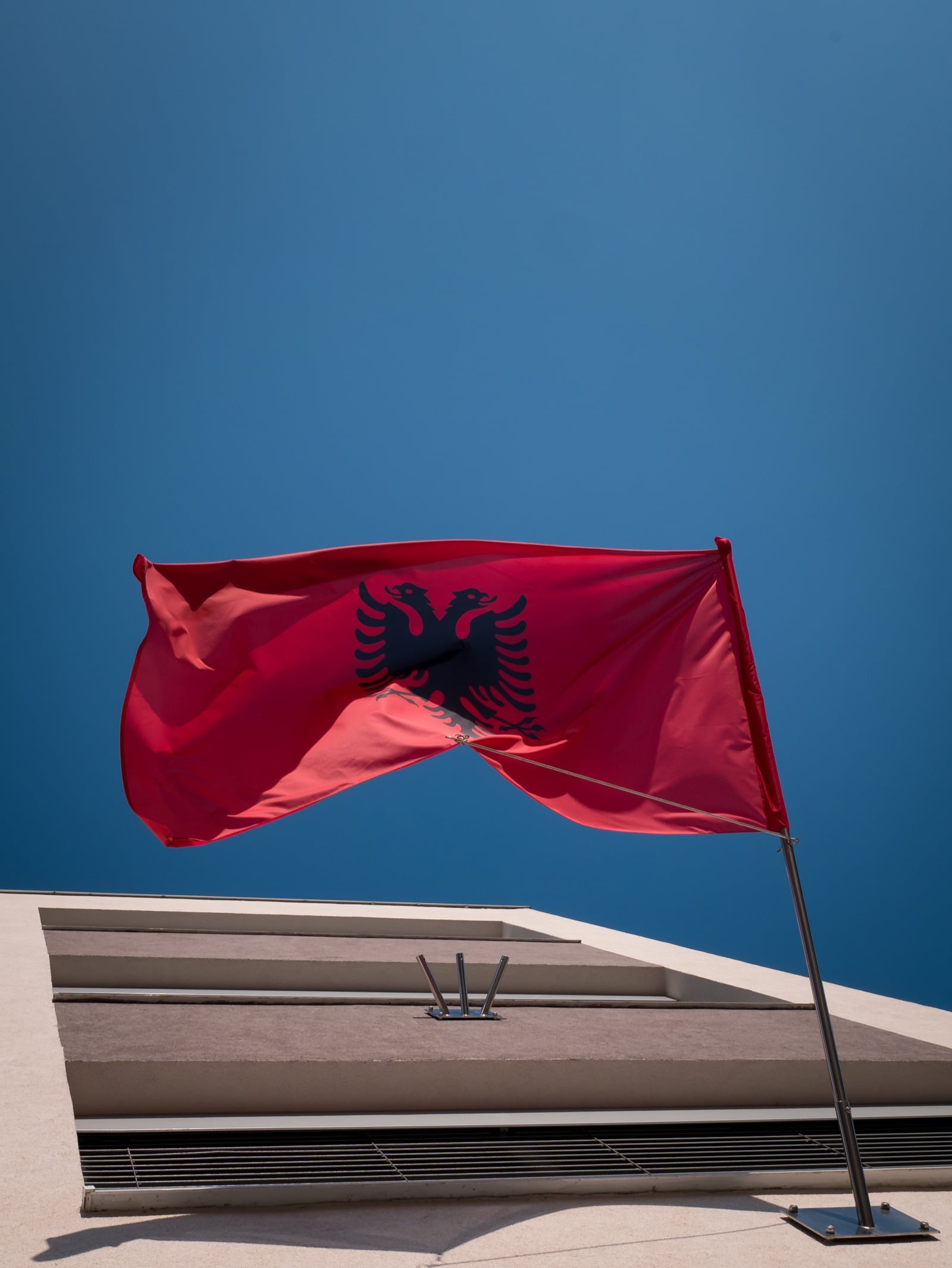 Flamuri shqiptar valëvitet në një qiell të kaltër të kthjellët