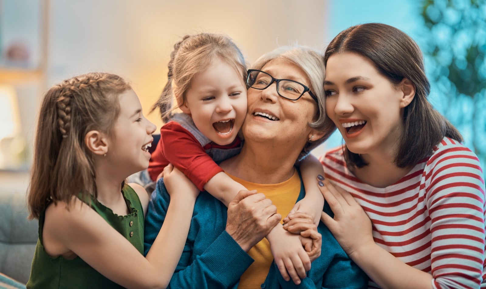 A grandmother, mother and children laughing together, three generations of one family