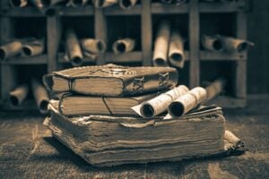 Vintage books and scrolls stacked on a wooden shelf, evoking the writers of the Albanian National Awakening