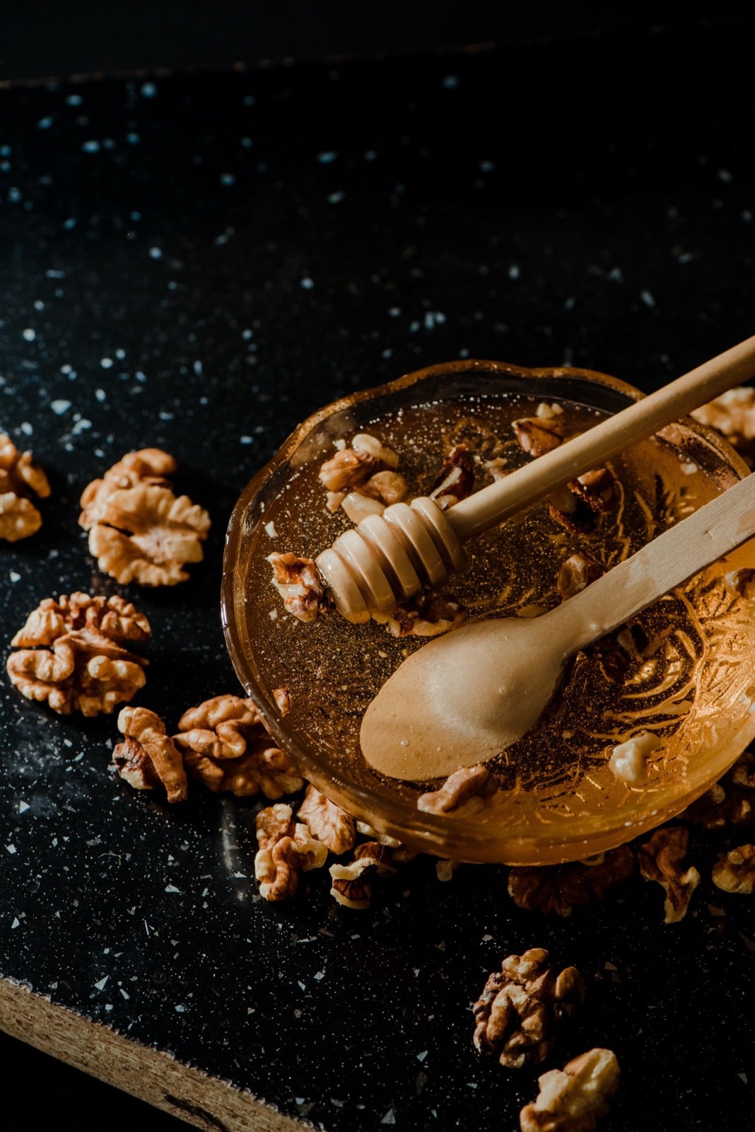 Honey and walnuts, the main ingredients of shëndetlie, on a dark surface